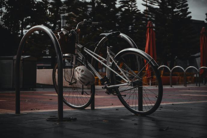 a bicycle is chained to a pole on a sidewalk